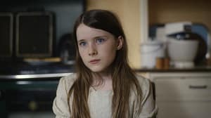 Picture of a young girl with long hair sitting in a kitchen for the new film The Quiet Girl 