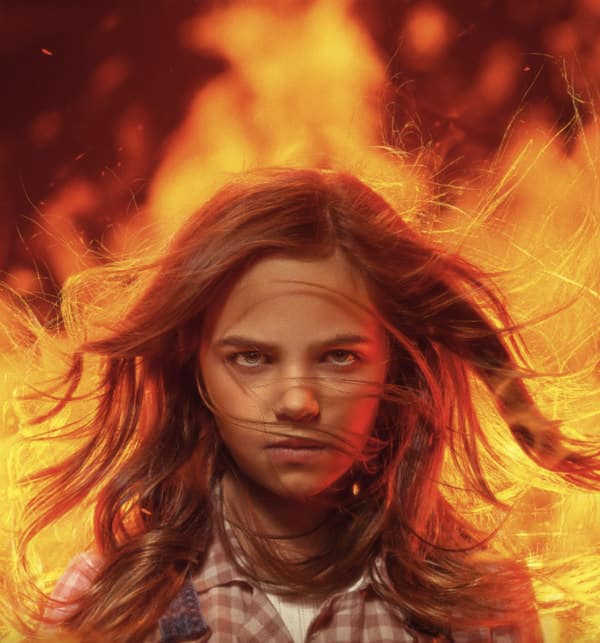 Young girl with long hair with fire in the background for the new film Firestarter